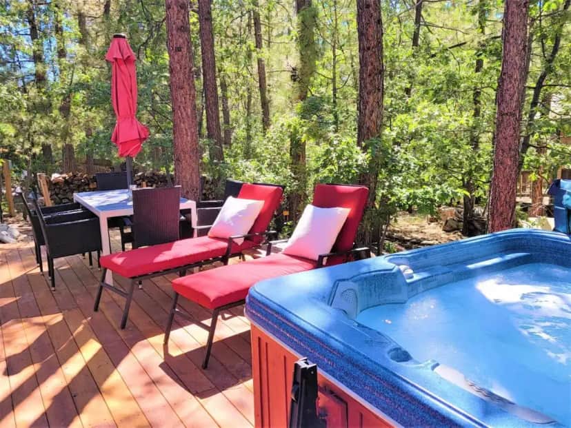 a hot tub on a deck with chairs and a table