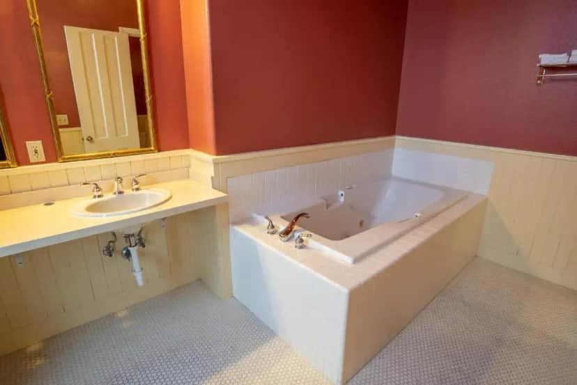 a bathroom with a bath tub and a sink at Geiser Grand Hotel in Baker City