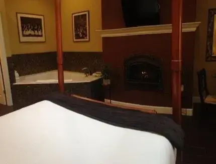 a bedroom with a bed and a fireplace and a tub at Glen Ellen Inn Secret Cottages in Glen Ellen