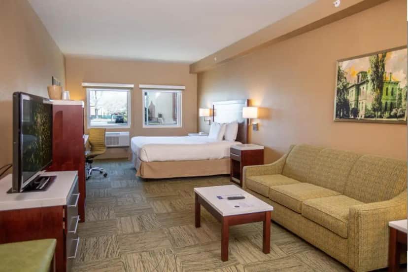 a hotel room with a bed and a couch and a tv at Gold Dust West in Carson City