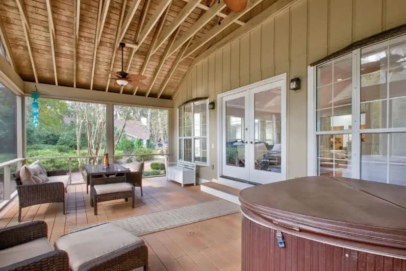 a screened in porch with a table and chairs at GOLF RETREAT with hottub and bikes is FUN4FAMILY incl PETS in Saint Simons Island