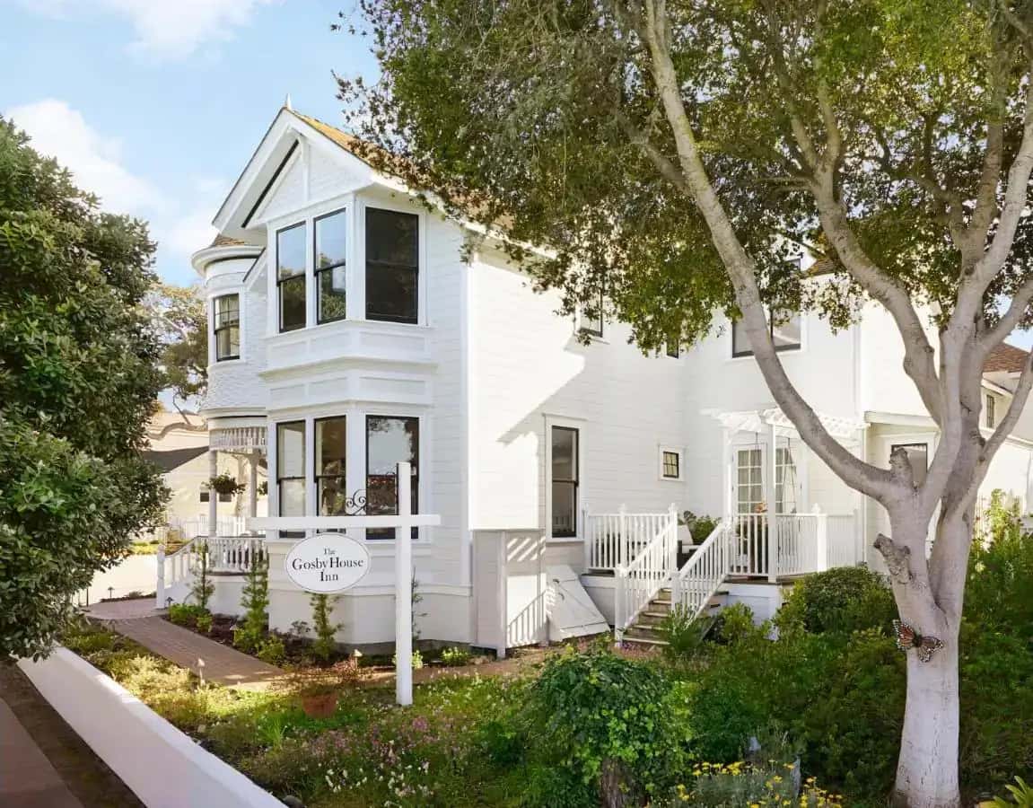 a white house with a tree in front of it at Gosby House Inn, A Four Sisters Inn in Pacific Grove