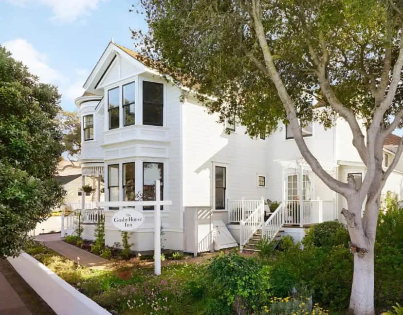 a white house with a tree in front of it at Gosby House Inn, A Four Sisters Inn in Pacific Grove