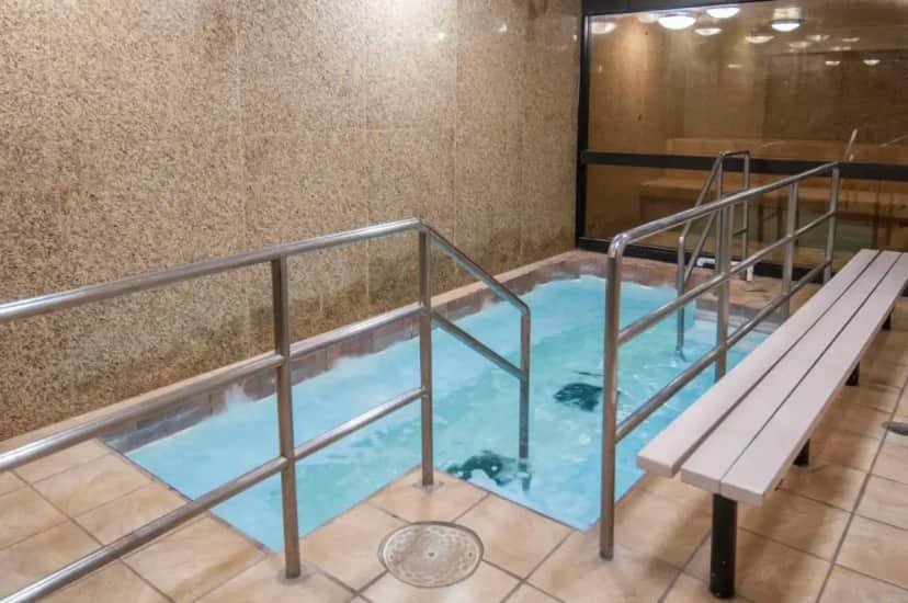 a hot tub with a bench in a building at Governors Suites Hotel Oklahoma City Airport Area in Oklahoma City