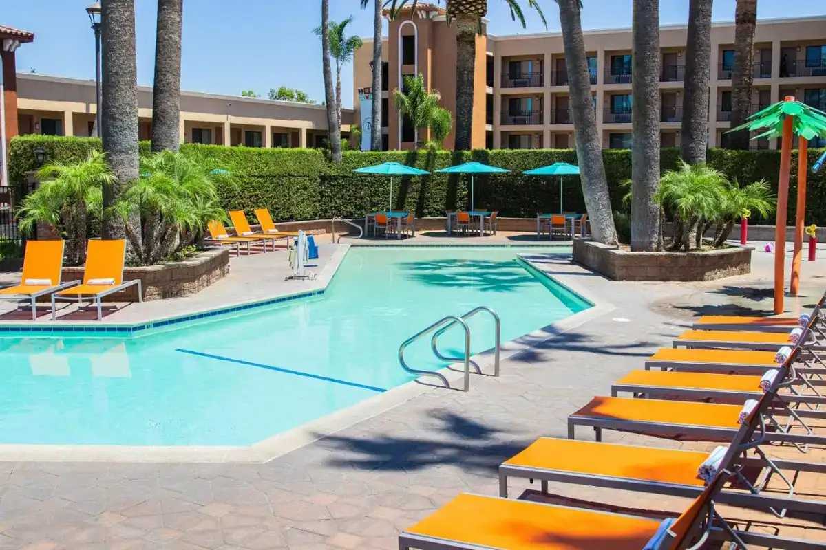 a swimming pool with lounge chairs and a hotel at Grand Legacy At The Park in Anaheim