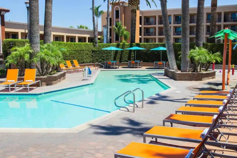 a swimming pool with lounge chairs and a hotel at Grand Legacy At The Park in Anaheim