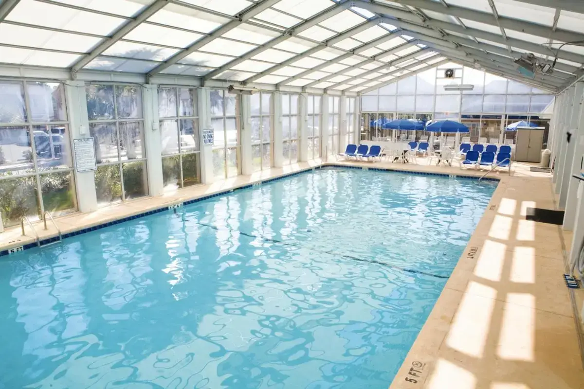 a large swimming pool with blue chairs in a building at Club Wyndham Grand Palms in Myrtle Beach