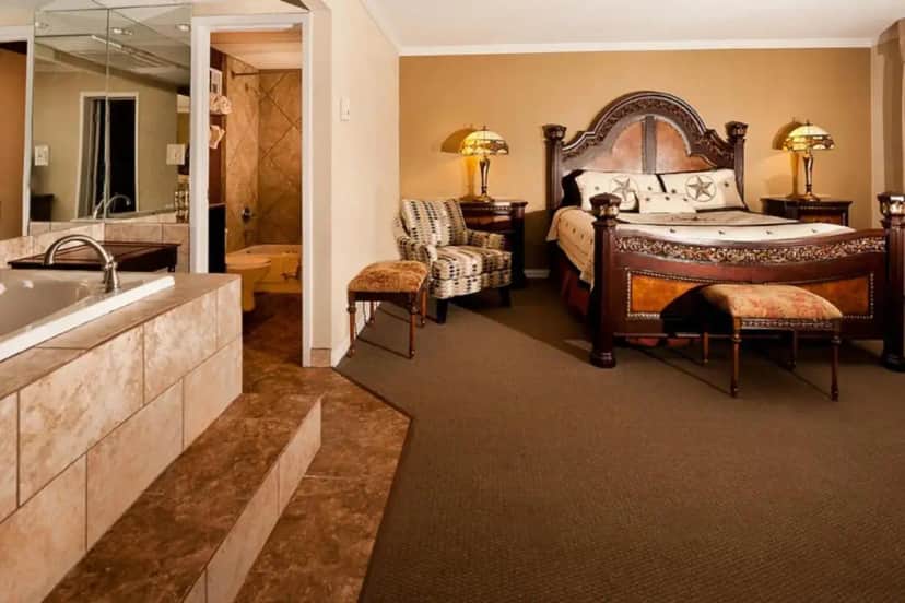 a bedroom with a large bed and a bath tub at Grand Texan Hotel and Convention Center in Midland