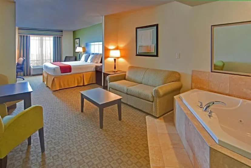 a hotel room with a bed and a bath tub at GreenTree Inn and Suites Florence, AZ in Florence