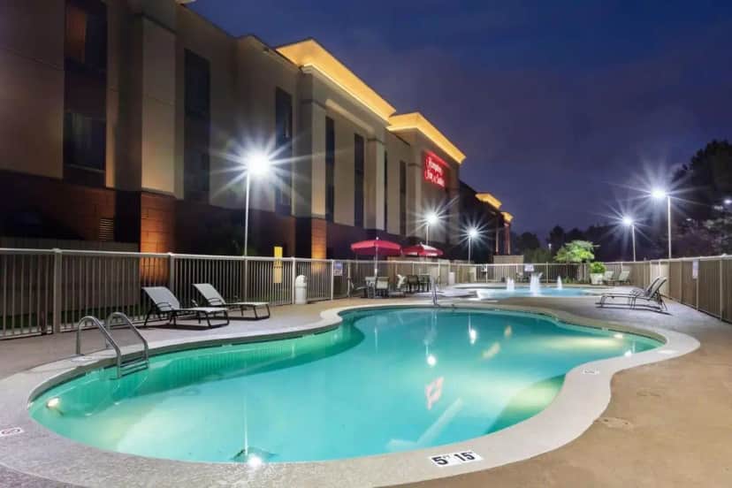 a pool in front of a hotel at night at Hampton Inn & Suites Baton Rouge - I-10 East in Nesser