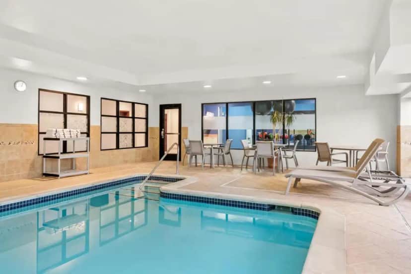 a pool in a hotel room with chairs and a table at Hampton Inn & Suites Detroit-Canton in Canton