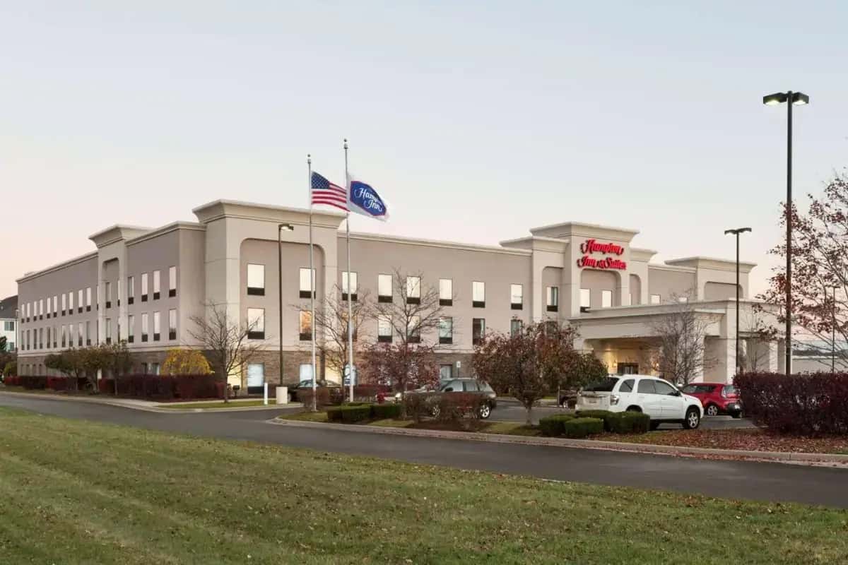 a building with an american flag in front of it at Hampton Inn & Suites Detroit Sterling Heights in Sterling Heights
