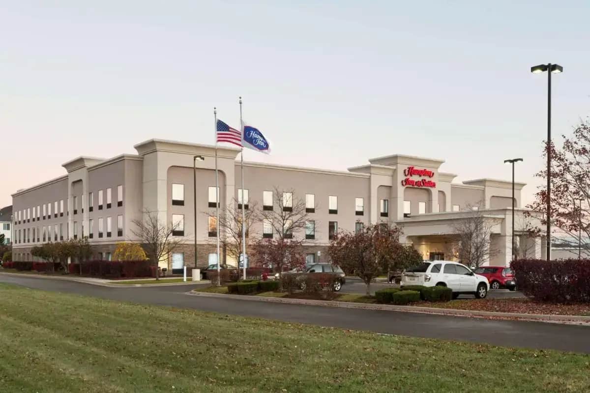 a building with an american flag in front of it at Hampton Inn & Suites Detroit Sterling Heights in Sterling Heights