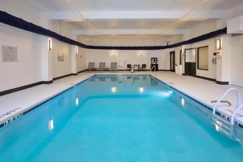 a large swimming pool with blue water in a building at Hampton Inn & Suites Spartanburg-I-26-Westgate Mall in Spartanburg