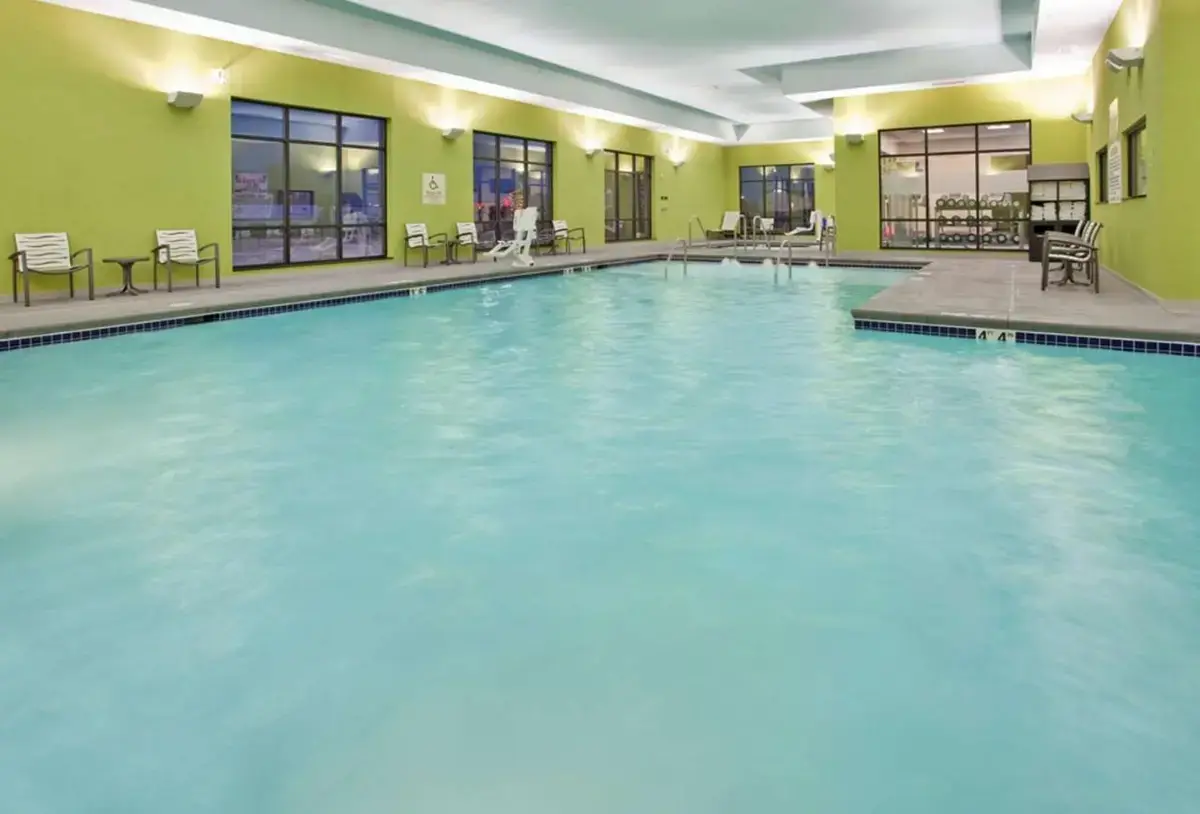 a large swimming pool with blue water in a building at Hampton Inn Kearney in Kearney