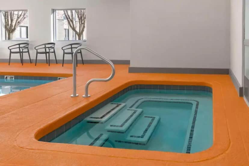 a hot tub in the middle of a room with chairs at Hampton Inn Olathe in Olathe