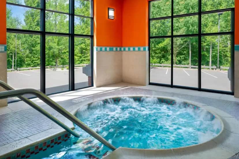 a hot tub in a room with windows at Hampton Inn Springfield South Enfield in Enfield