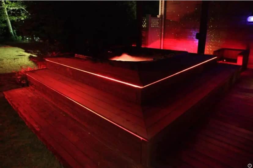 a hot tub with red lights on a deck at Hamptons 9BD MEGA Compound w POOL TENNIS BBALL NIGHTCLUB in Sag Harbor