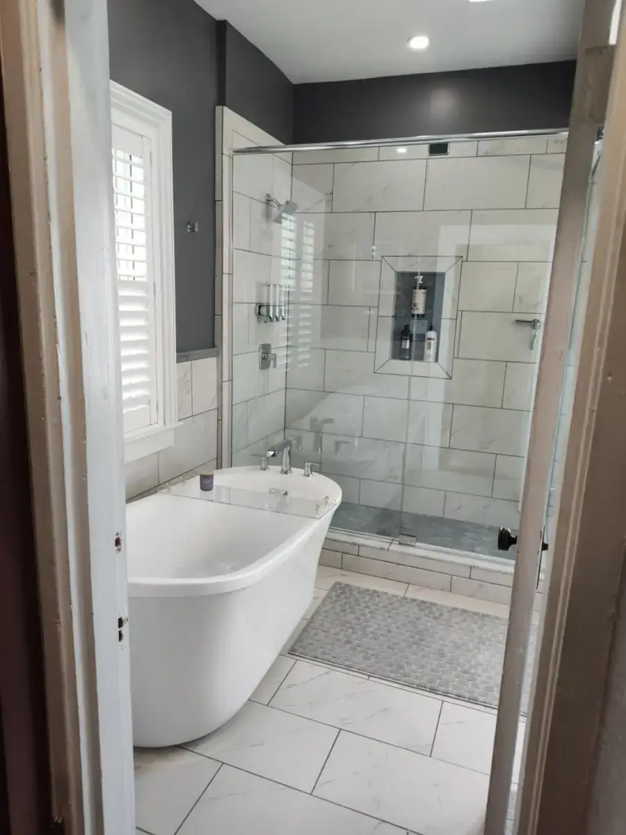 a bathroom with a white tub and a shower at Hickory House B & B in Hickory