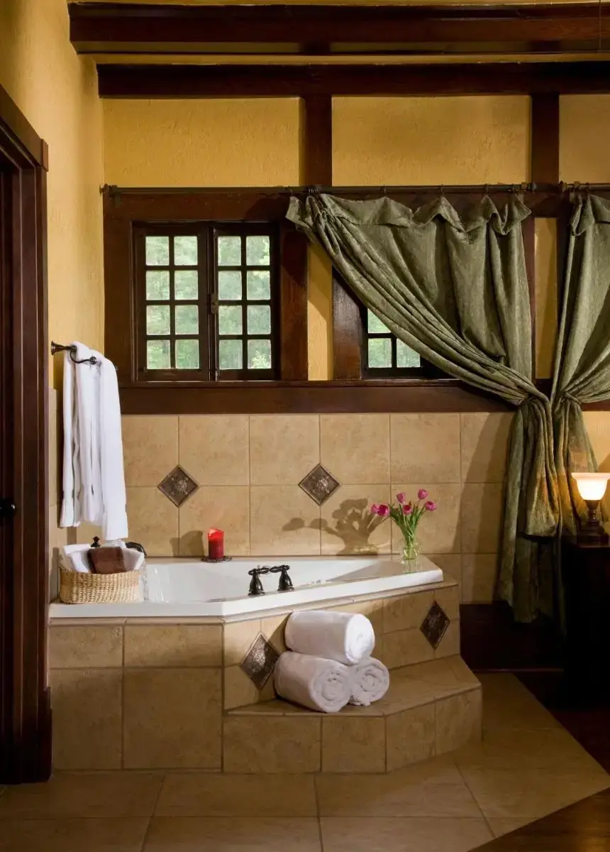 a bathroom with a bath tub with towels in it at Hilltop Manor B&B in Hot Springs