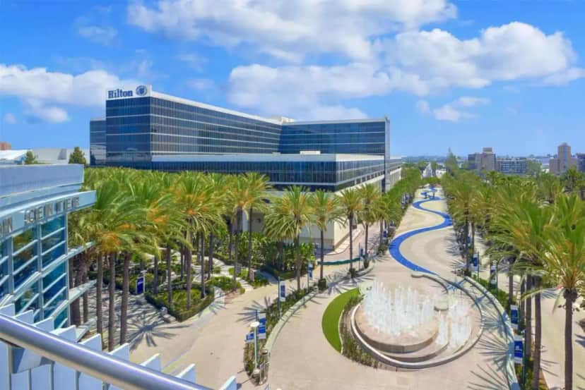 a view of a building with palm trees and a walkway at Hilton Anaheim in Anaheim