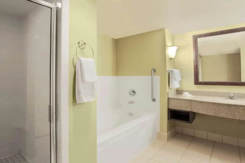 a bathroom with a tub and a sink and a mirror at Hilton Garden Inn Chicago/Midway Airport in Chicago