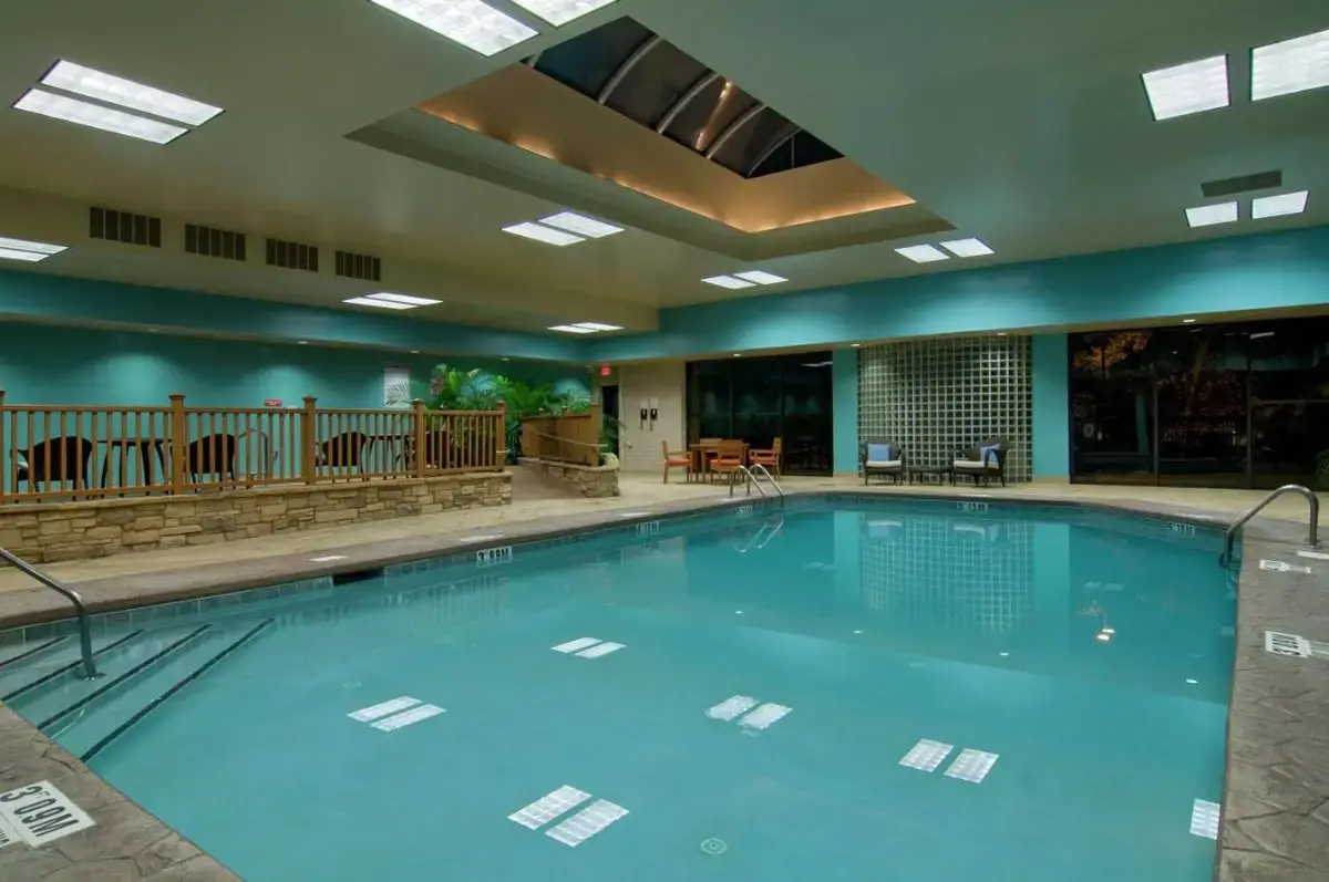 a large swimming pool with blue water in a building at Hilton Raleigh North Hills in Raleigh