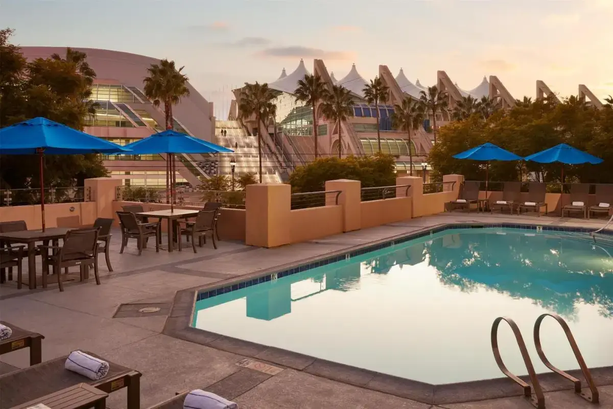 a swimming pool with tables and chairs and umbrellas at Hilton San Diego Gaslamp Quarter in San Diego