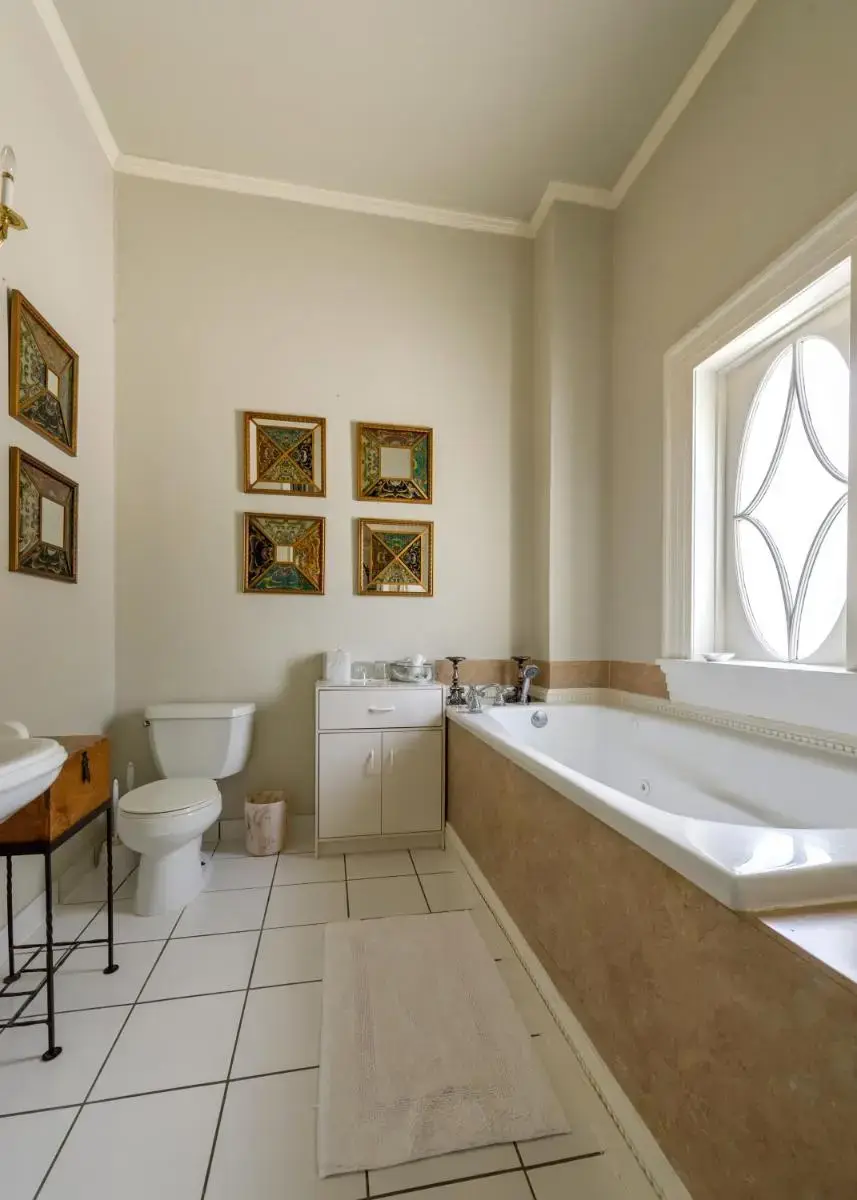 a bathroom with a tub and a toilet and a sink at Historic Michabelle Inn in Hammond