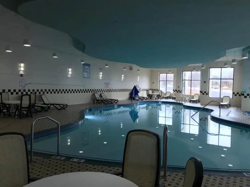 a large swimming pool in a room with tables and chairs at Holiday Inn Hotel & Suites Chicago Northwest - Elgin by IHG in Elgin
