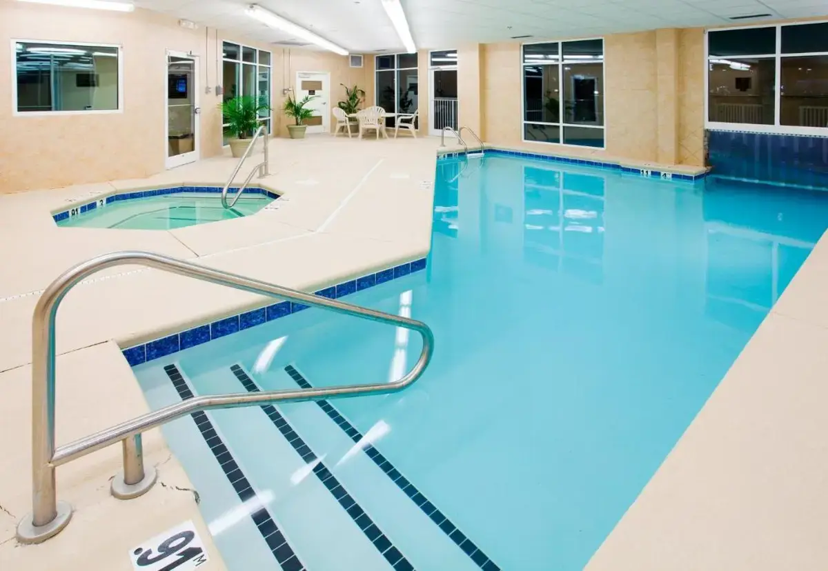a large swimming pool with blue water in a building at Holiday Inn Express & Suites Asheville Downtown by IHG in Asheville