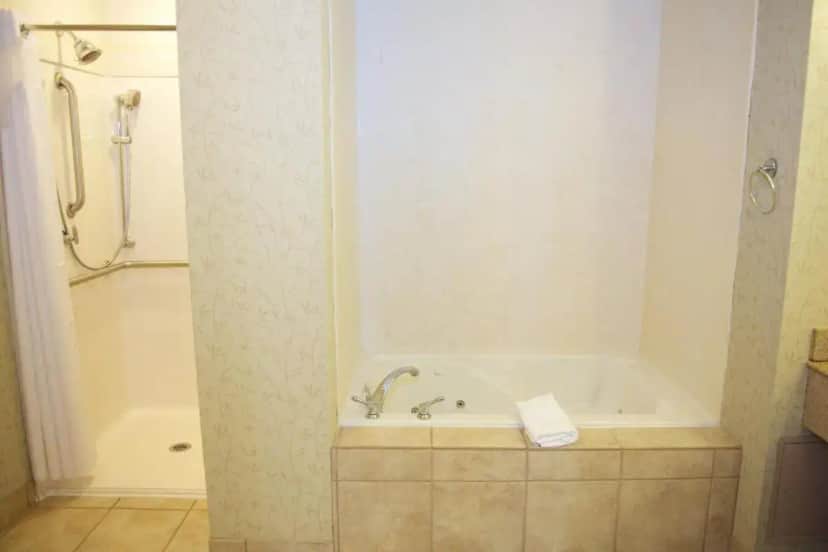 a bathroom with a bath tub and a shower at Holiday Inn Effingham by IHG in Effingham
