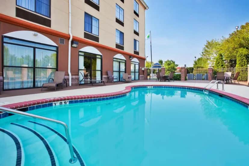 a swimming pool in front of a building at Holiday Inn Express & Suites Charlotte-Concord-I-85 by IHG in Harrisburg