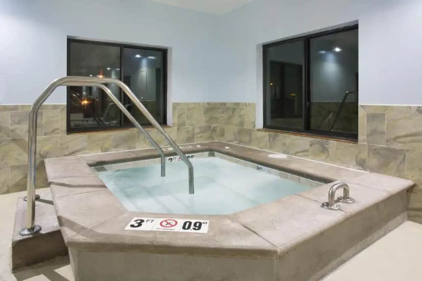 a jacuzzi tub in a room with windows at Holiday Inn Express Hotel & Suites Concordia US 81 by IHG in Concordia