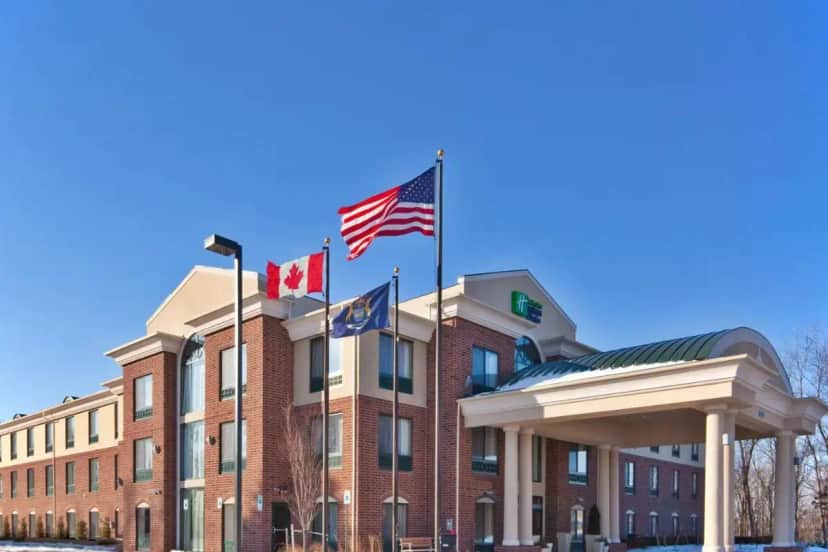 a building with three flags in front of it at Holiday Inn Express & Suites Detroit - Novi by IHG in Novi