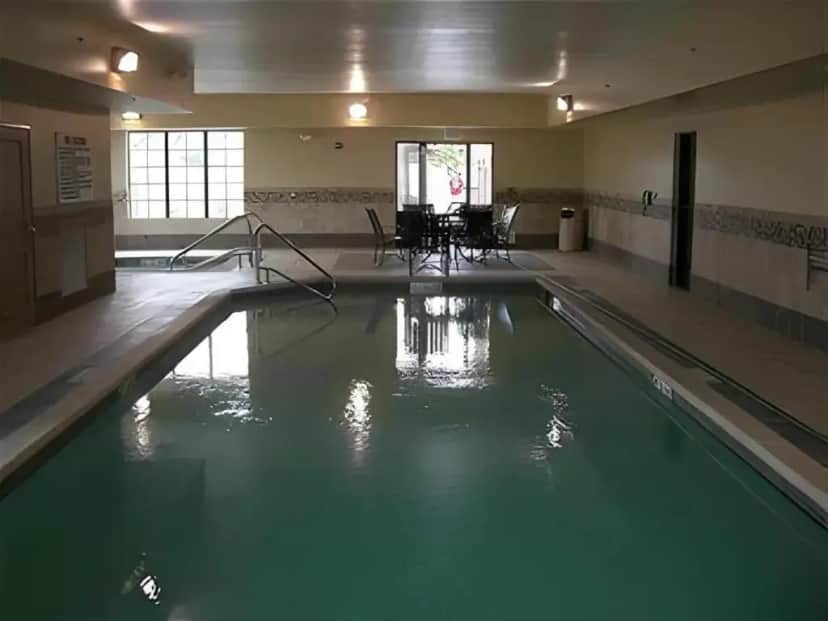 a swimming pool with green water in a building at Holiday Inn Express Hotel & Suites Grand Island By IHG in Grand Island