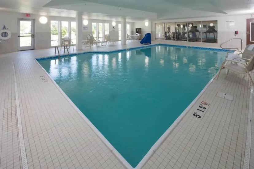 a large pool with blue water in a building at Holiday Inn Express & Suites Port Huron by IHG in Port Huron