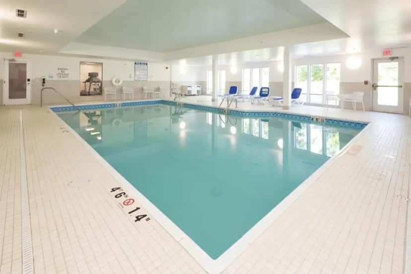 a large swimming pool with blue water in a building at Holiday Inn Express & Suites - Portage by IHG in Portage