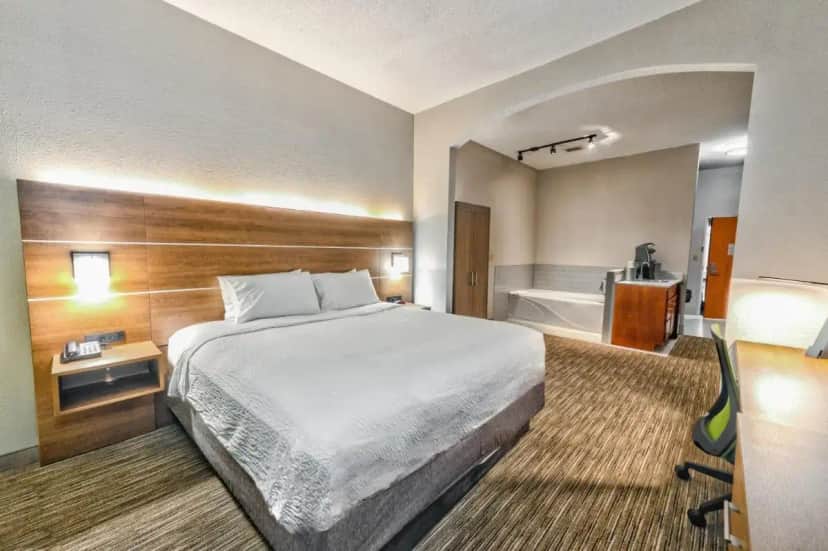 a hotel room with a bed and a bath tub at Holiday Inn Express Hotel & Suites Goshen by IHG in Goshen