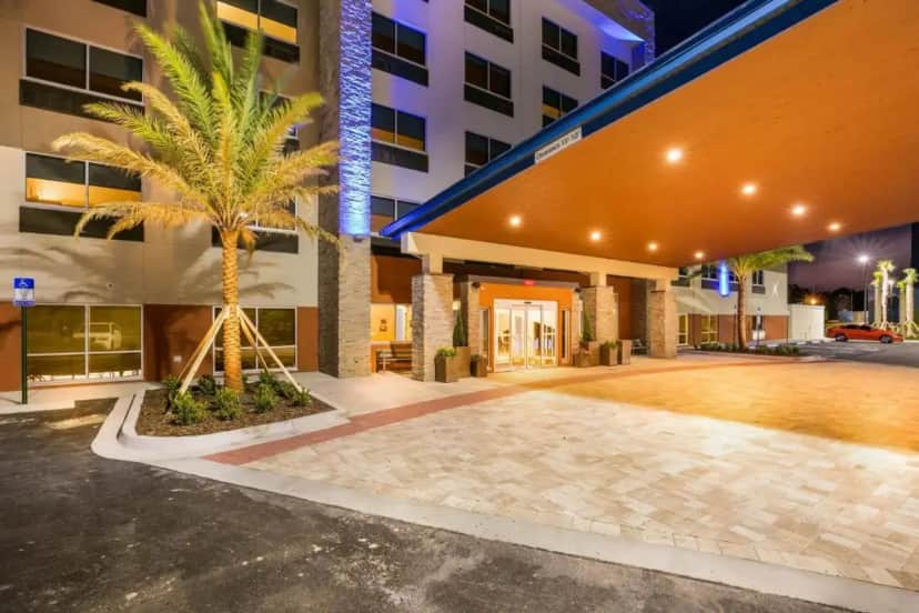 a building with a palm tree in front of it at Holiday Inn Express & Suites Jacksonville - Town Center by IHG in Jacksonville
