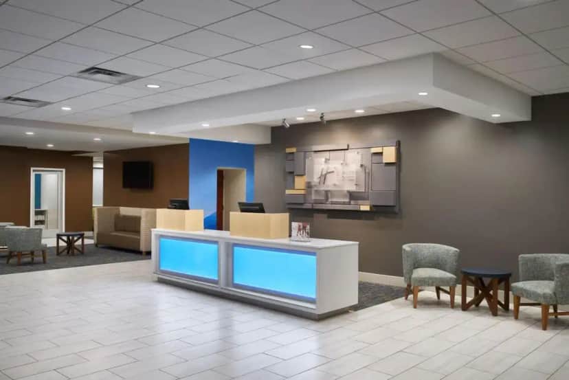 a lobby with a waiting room with chairs and a counter at Holiday Inn Express - Richmond Downtown by IHG in Richmond