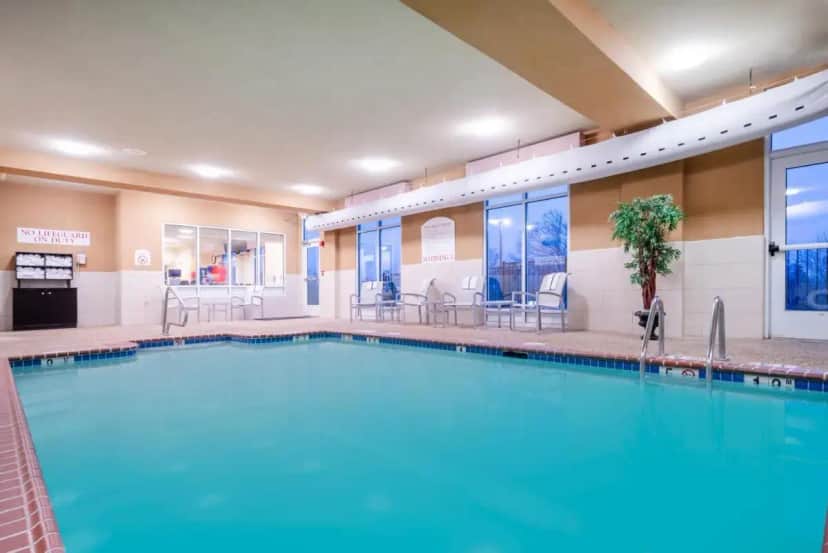 a pool at a hotel with tables and chairs at Holiday Inn Manassas - Battlefield by IHG in Manassas