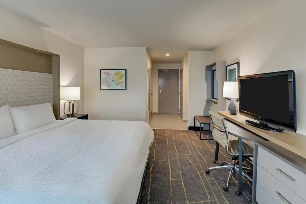 a hotel room with a bed and a flat screen tv at Holiday Inn Mobile Airport by IHG in Mobile