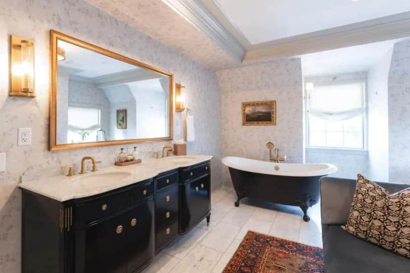 a bathroom with a tub and a sink and a mirror at Hotel Burg in Leesburg