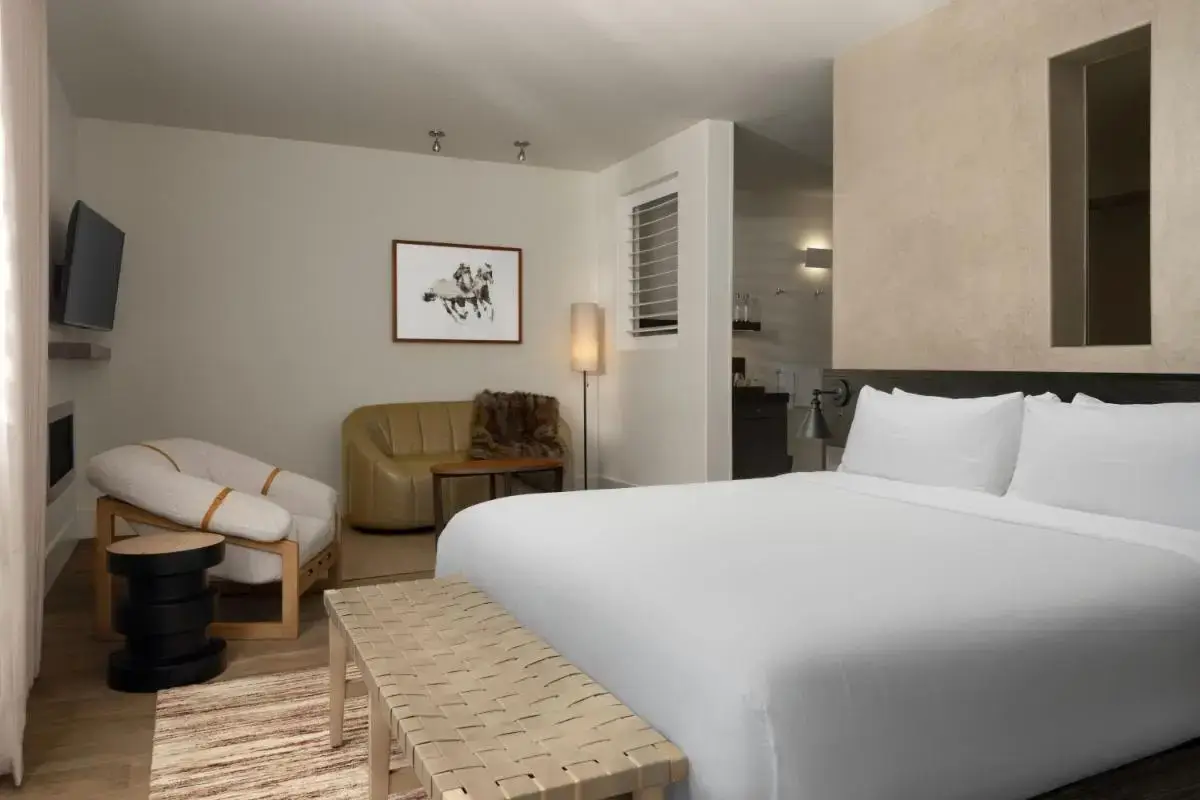 a bedroom with a large white bed and a chair at HOTEL CERRO, Autograph Collection in San Luis Obispo