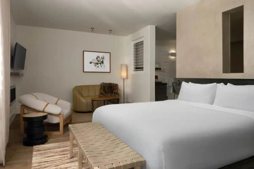 a bedroom with a large white bed and a chair at HOTEL CERRO, Autograph Collection in San Luis Obispo