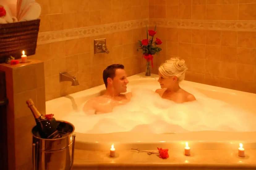 a man and woman in a bath tub with candles at Hotel Iris - Mission Valley-San Diego Zoo-SeaWorld in San Diego