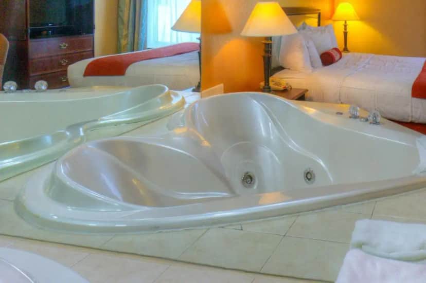 a bath tub in a hotel room with two beds at Hotel M Mount Pocono in Mount Pocono