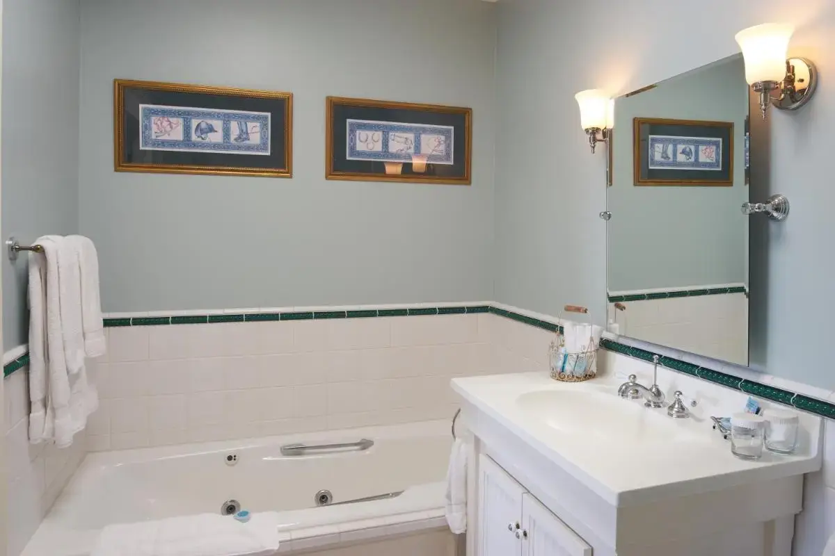 a white bathroom with a sink and a tub and a mirror at Hotel Mac in Richmond