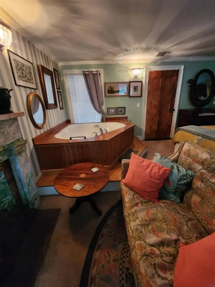 a living room with a tub and a couch at House of 1833 Bed and Breakfast in Mystic